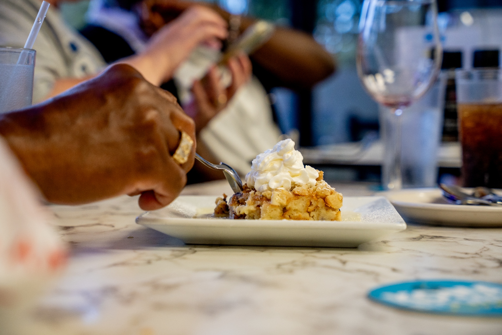 Guests sharing bread pudding at the table — Luc's Seafood & Grill